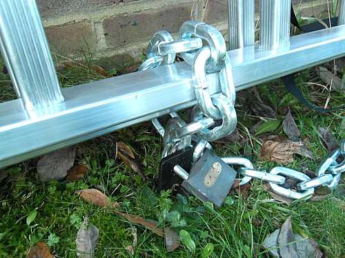 Ancrage au sol, chaîne et cadenas sur échelle en aluminium. Gros plan